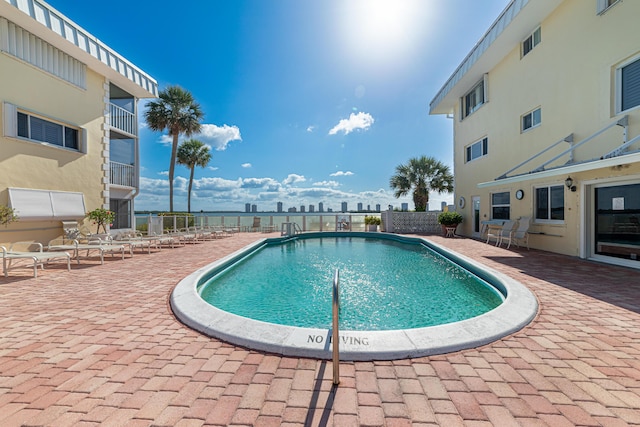 pool with a patio and fence