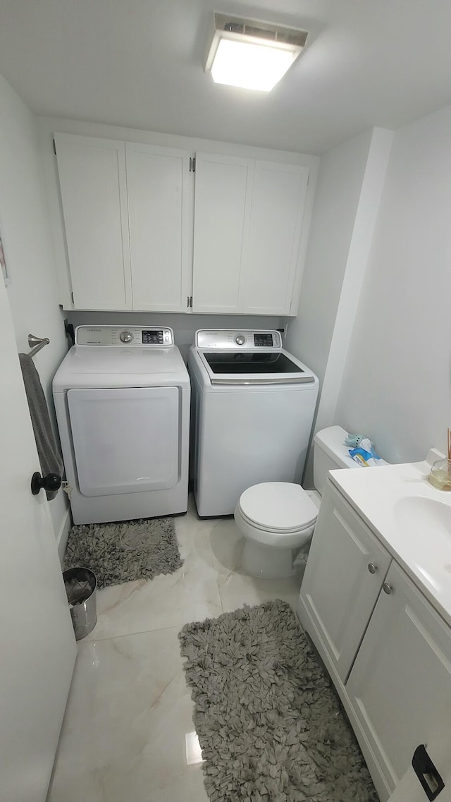 bathroom with toilet, washer and dryer, and vanity