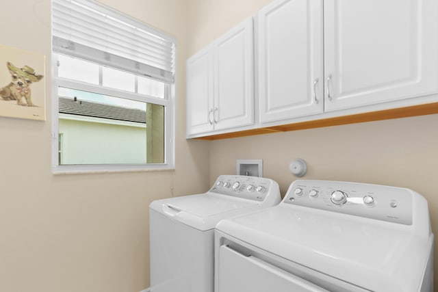 clothes washing area with cabinet space and washing machine and clothes dryer