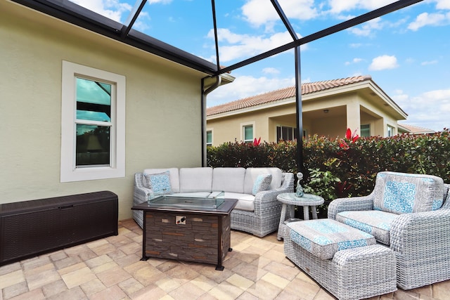 view of patio / terrace featuring radiator, an outdoor living space with a fire pit, and glass enclosure