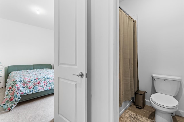 1218 Timber Reap Trl, The Acreage, FL 33470 - bathroom featuring baseboards, wood finished floors, a shower with curtain, and toilet