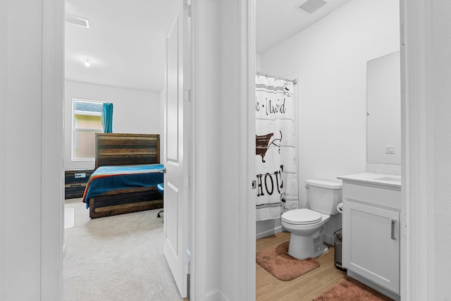 1218 Timber Reap Trl, The Acreage, FL 33470 - full bath with wood finished floors, visible vents, toilet, vanity, and ensuite bathroom