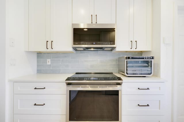 144 Pennock Landing Cir, Jupiter, FL 33458 - kitchen featuring stainless steel appliances, light countertops, white cabinetry, and backsplash