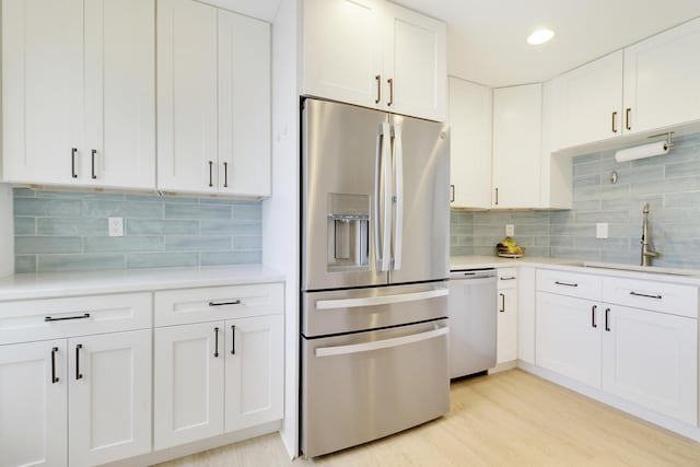 144 Pennock Landing Cir, Jupiter, FL 33458 - kitchen with appliances with stainless steel finishes, a sink, light countertops, white cabinets, and backsplash