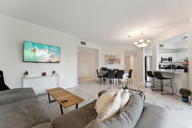 living area with an inviting chandelier, marble finish floor, and visible vents