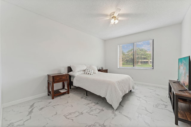 bedroom featuring baseboards, marble finish floor, ceiling fan, and a textured ceiling