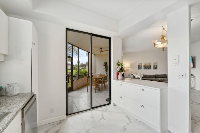 entryway with marble finish floor and baseboards