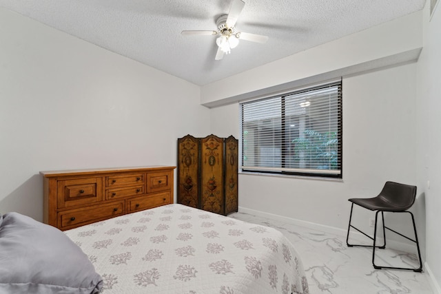 bedroom with baseboards, a ceiling fan, marble finish floor, and a textured ceiling