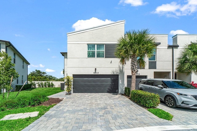 5612 Mentmore Dr, West Palm Beach, FL 33407 - view of front of property with an attached garage, stucco siding, and decorative driveway