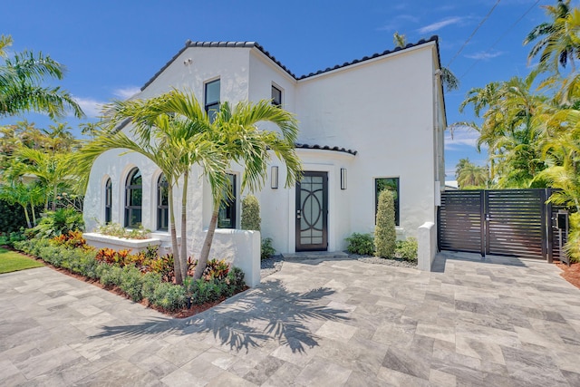 5832 Alton Rd, Miami Beach, FL 33140 - mediterranean / spanish-style house featuring a tile roof, fence, stucco siding, and a gate