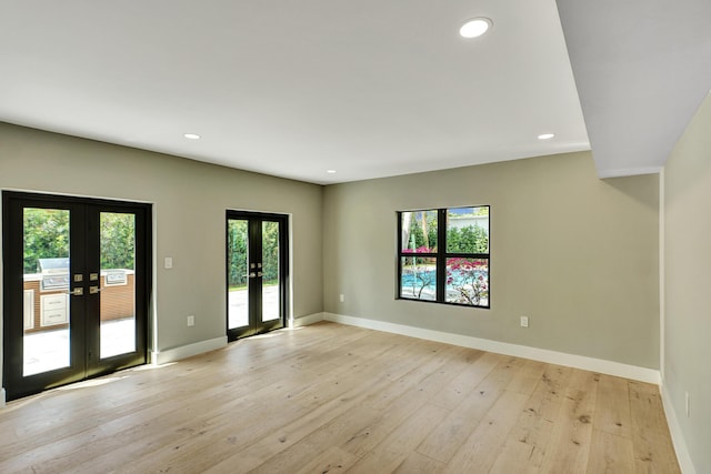 5832 Alton Rd, Miami Beach, FL 33140 - unfurnished living room featuring french doors, light wood finished floors, and baseboards
