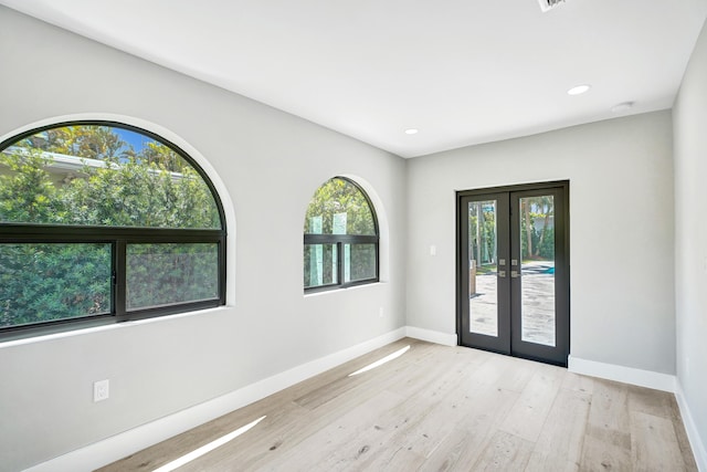 5832 Alton Rd, Miami Beach, FL 33140 - entryway with light wood finished floors, french doors, and baseboards