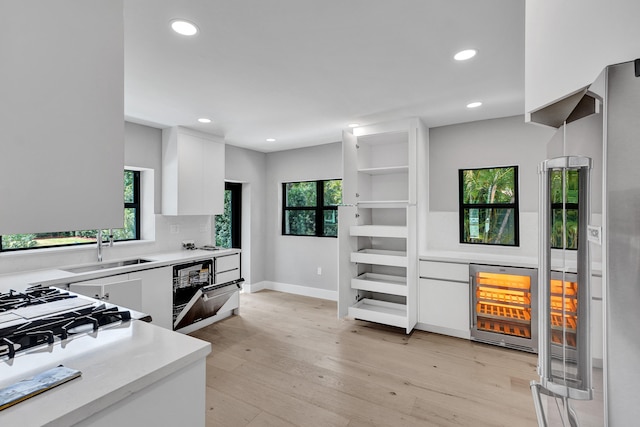 5832 Alton Rd, Miami Beach, FL 33140 - kitchen with white cabinetry, a sink, beverage cooler, light countertops, and recessed lighting