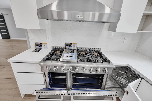 5832 Alton Rd, Miami Beach, FL 33140 - details with light wood-style flooring, wall chimney exhaust hood, range with two ovens, and tasteful backsplash