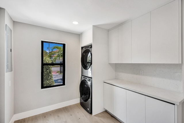 5832 Alton Rd, Miami Beach, FL 33140 - laundry area with recessed lighting, light wood-style flooring, cabinet space, baseboards, and stacked washer and clothes dryer