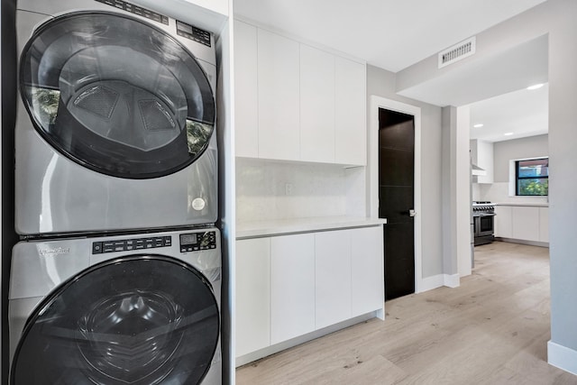 5832 Alton Rd, Miami Beach, FL 33140 - washroom featuring laundry area, light wood-style flooring, baseboards, visible vents, and stacked washer and clothes dryer