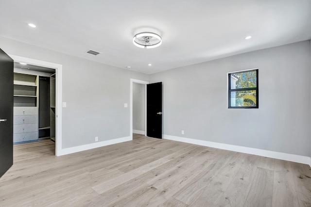 5832 Alton Rd, Miami Beach, FL 33140 - unfurnished bedroom with recessed lighting, a walk in closet, visible vents, light wood-style flooring, and baseboards
