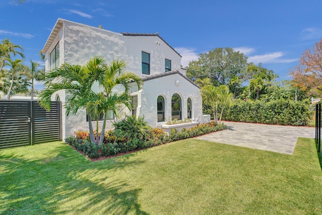 5832 Alton Rd, Miami Beach, FL 33140 - back of property featuring a lawn, stucco siding, and fence
