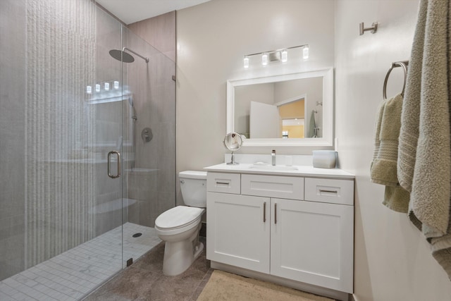 full bath with toilet, vanity, a shower stall, and tile patterned flooring