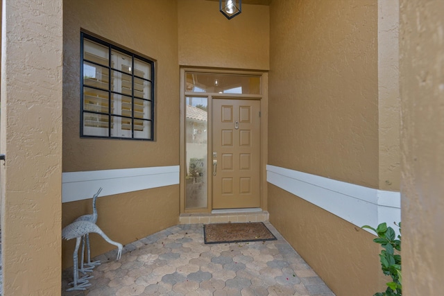 view of exterior entry with stucco siding