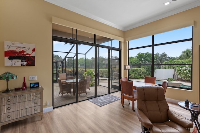 sunroom with baseboards, ornamental molding, and wood finished floors