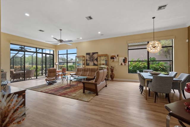 living area with a healthy amount of sunlight, light wood finished floors, and visible vents