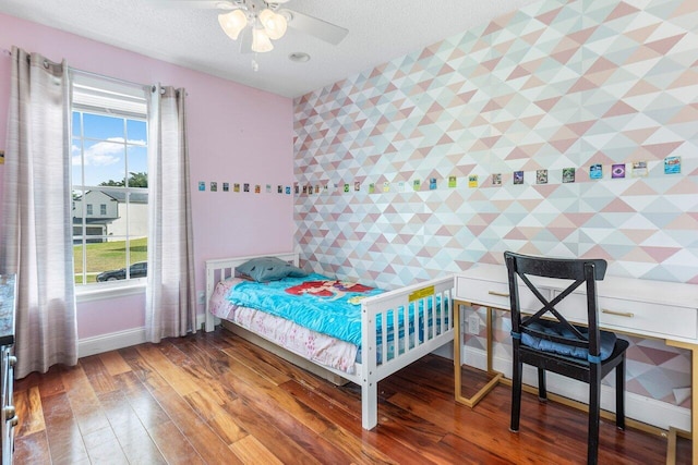 12820 Smithdale Pl, Boca Raton, FL 33428 - bedroom with a textured ceiling, wood finished floors, an accent wall, and baseboards