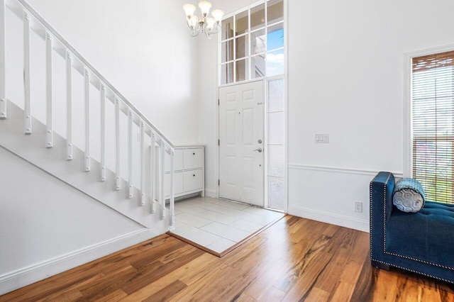 12820 Smithdale Pl, Boca Raton, FL 33428 - entryway with baseboards, a chandelier, wood finished floors, and stairs