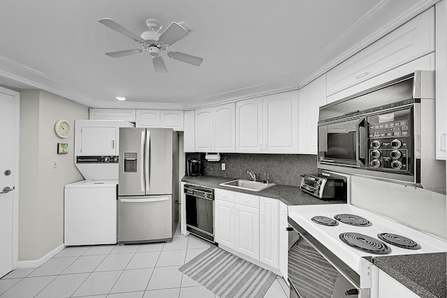 701 E Camino Real Unit 4B, Boca Raton, FL 33432 - kitchen featuring black appliances, stacked washer and clothes dryer, a sink, and white cabinetry