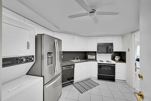 701 E Camino Real Unit 4B, Boca Raton, FL 33432 - kitchen with black appliances, stacked washer and clothes dryer, a sink, white cabinets, and decorative backsplash