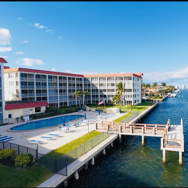 dock area with a water view, fence, a community pool, and a patio