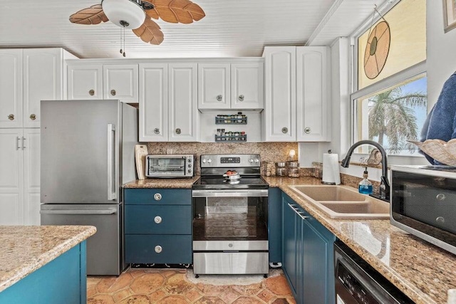 kitchen with appliances with stainless steel finishes, a sink, blue cabinets, and white cabinets