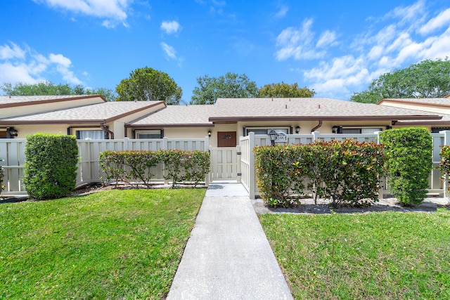 ranch-style house with a front yard, fence, a gate, and roof with shingles