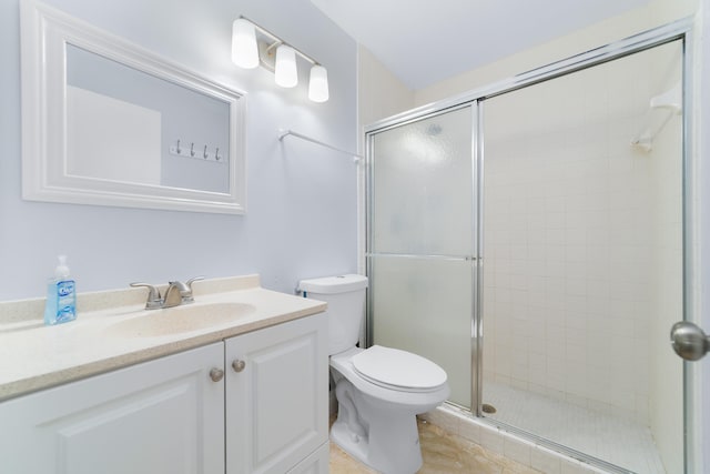 bathroom with tile patterned floors, toilet, vanity, and a stall shower