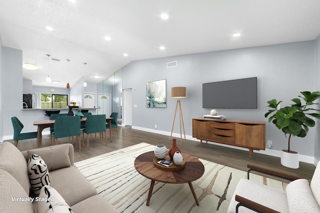 living room with wood finished floors, baseboards, vaulted ceiling, and visible vents