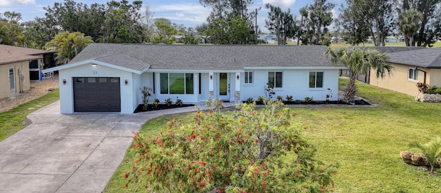 ranch-style home with driveway, a shingled roof, an attached garage, a front yard, and stucco siding