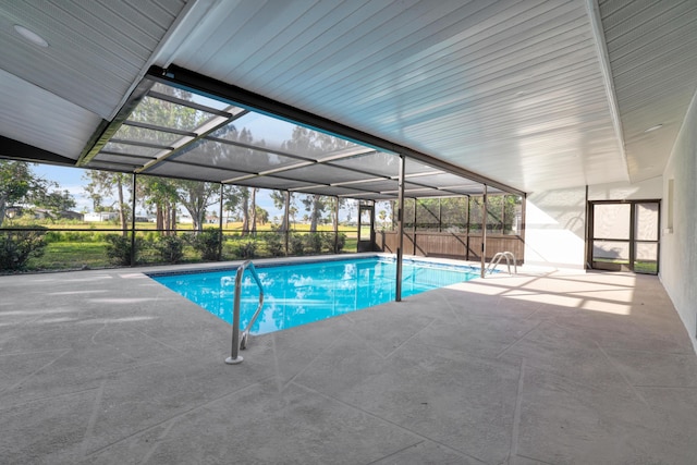 pool with glass enclosure and a patio