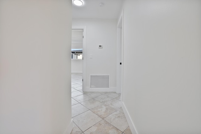 hall featuring baseboards and visible vents