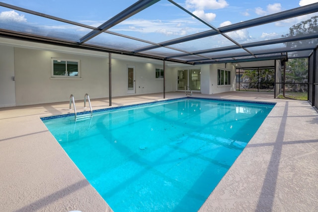 outdoor pool with glass enclosure and a patio