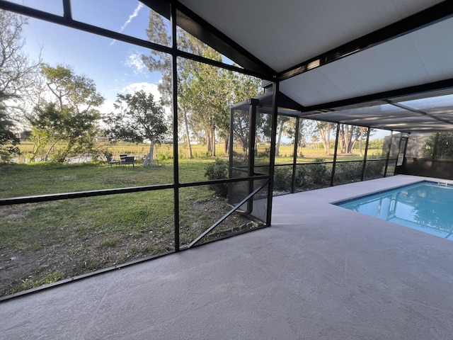 view of swimming pool with glass enclosure, a patio area, and a lawn