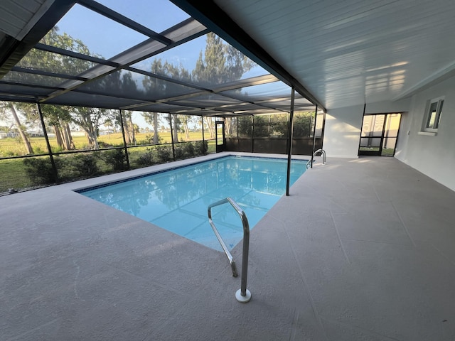 outdoor pool featuring glass enclosure and a patio