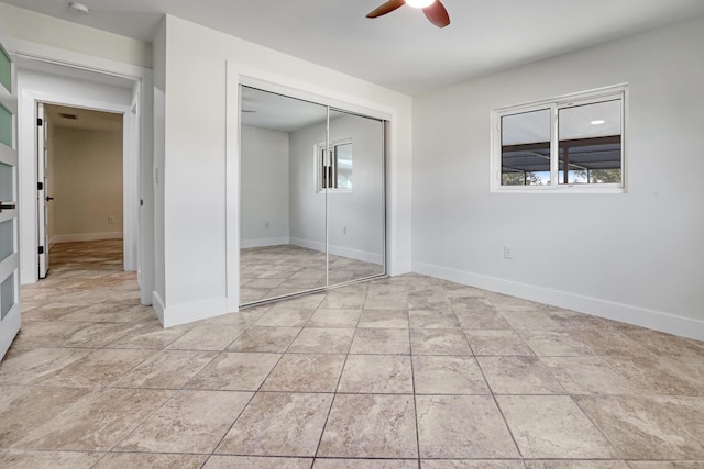 unfurnished bedroom with a closet, a ceiling fan, and baseboards
