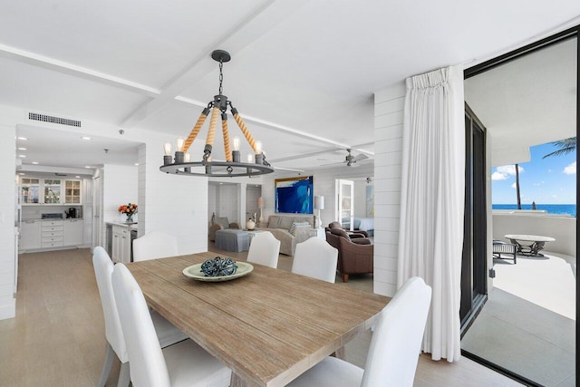 2917 S Ocean Blvd Unit 104, Highland Beach, FL 33487 - dining space with a chandelier, beam ceiling, and a ceiling fan