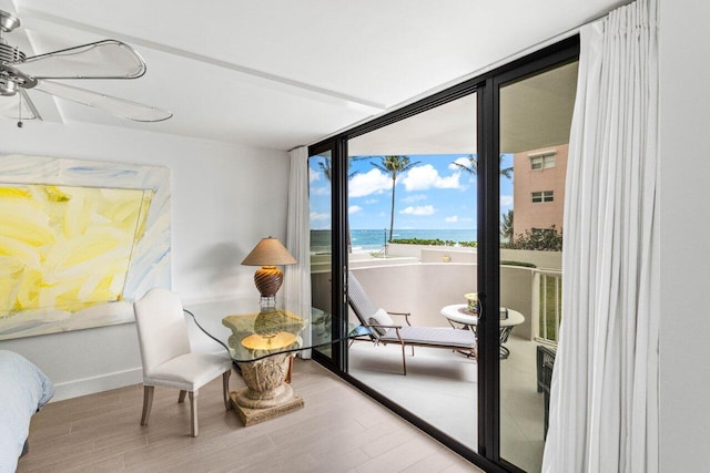 2917 S Ocean Blvd Unit 104, Highland Beach, FL 33487 - sitting room featuring wood finished floors, a ceiling fan, expansive windows, baseboards, and a water view