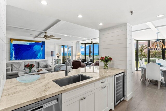 2917 S Ocean Blvd Unit 104, Highland Beach, FL 33487 - kitchen with a sink, beverage cooler, stainless steel dishwasher, wood walls, and open floor plan