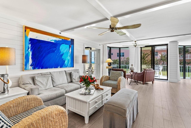 2917 S Ocean Blvd Unit 104, Highland Beach, FL 33487 - living area featuring healthy amount of natural light, ceiling fan, wood walls, wood finished floors, and beamed ceiling