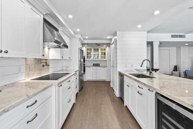 2917 S Ocean Blvd Unit 104, Highland Beach, FL 33487 - kitchen featuring wall chimney exhaust hood, a sink, appliances with stainless steel finishes, beverage cooler, and recessed lighting