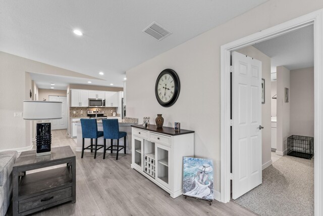 14423 Dalia Ave, Fort Pierce, FL 34951 - hall featuring visible vents, baseboards, recessed lighting, light wood-style flooring, and lofted ceiling