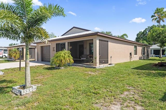 14423 Dalia Ave, Fort Pierce, FL 34951 - view of front of property featuring concrete driveway, stucco siding, an attached garage, a front lawn, and a sunroom