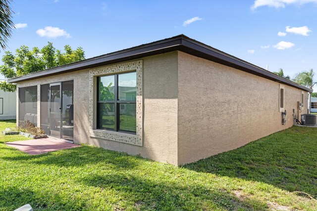 14423 Dalia Ave, Fort Pierce, FL 34951 - view of property exterior featuring central air condition unit, stucco siding, and a lawn
